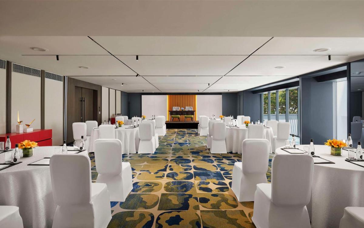 a banquet hall with white tables and white chairs at Hyatt Centric Hebbal Bengaluru in Bengaluru