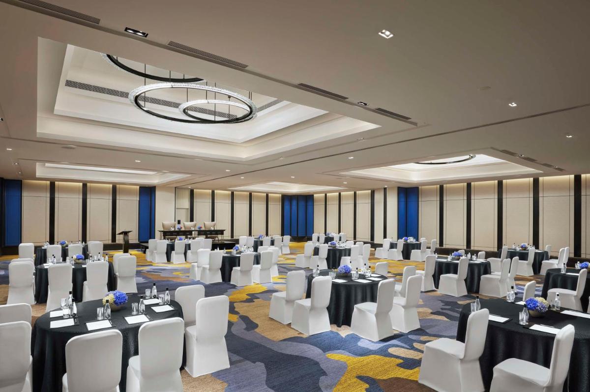 a banquet hall with white chairs and tables in a room at Hyatt Centric Hebbal Bengaluru in Bengaluru