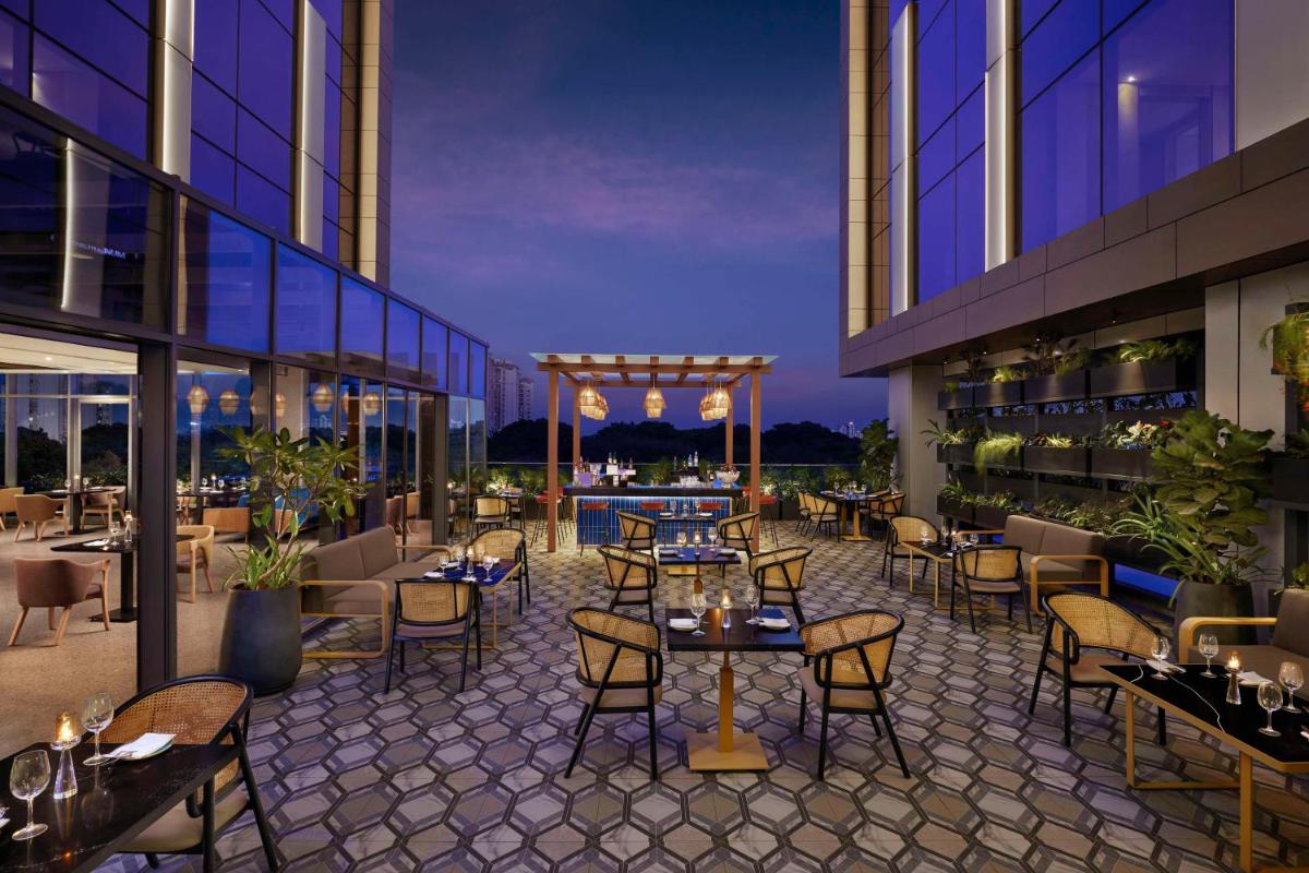 a restaurant with tables and chairs on a building at Hyatt Centric Hebbal Bengaluru in Bengaluru