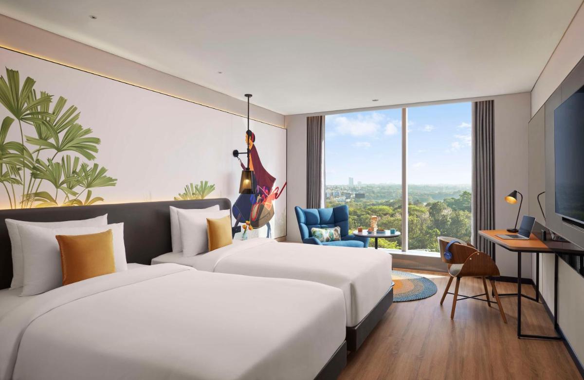 a hotel room with a large bed and a large window at Hyatt Centric Hebbal Bengaluru in Bengaluru