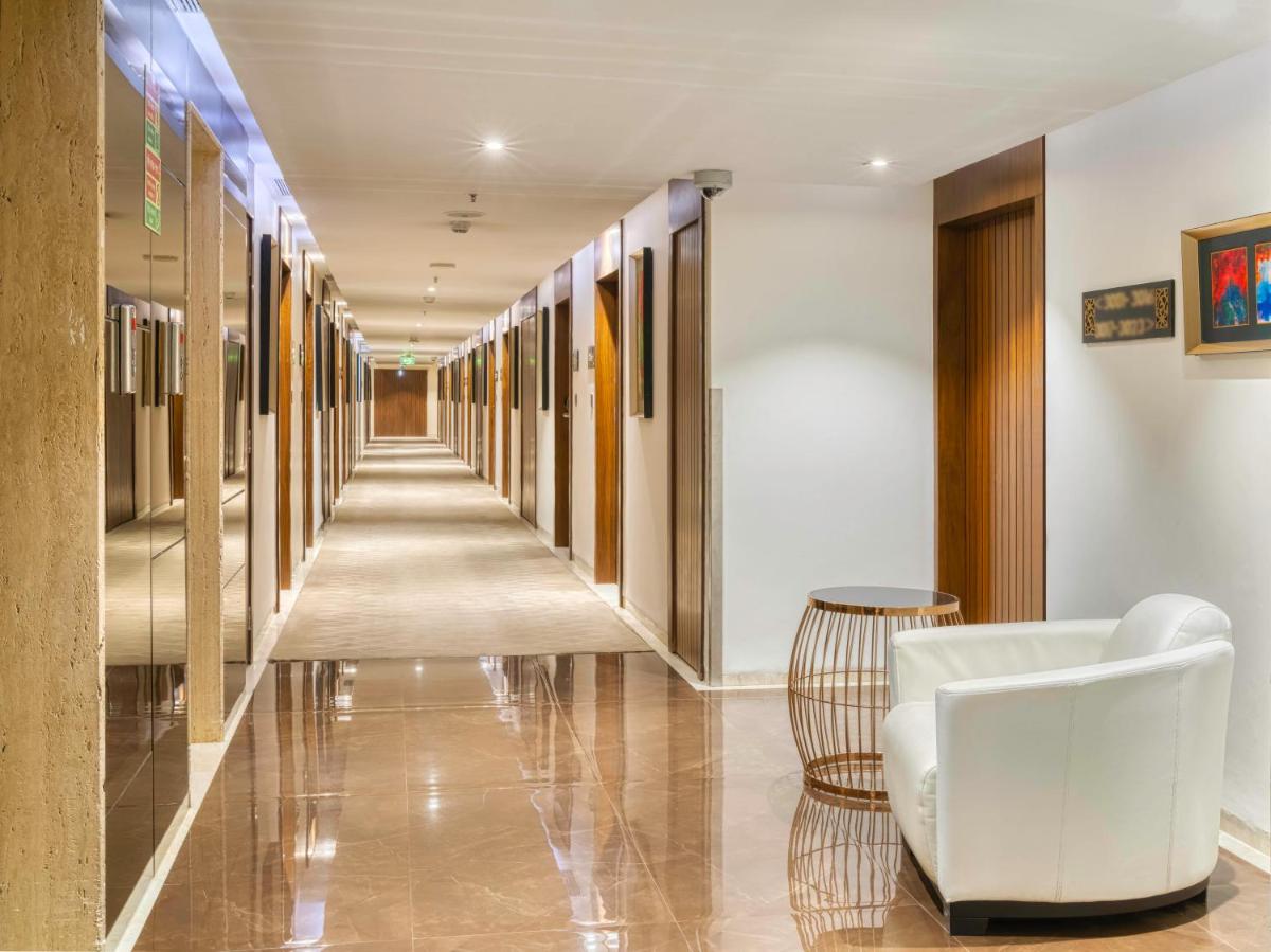 a hallway with a white couch and a chair at Holiday Inn Kolkata Airport by IHG in Kolkata