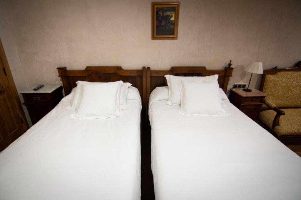 Cama o camas de una habitación en Hospedium Hotel Rural Abadía de Yuste