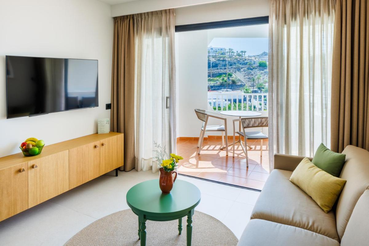 Una sala de estar con un sofá y un televisor. en Hapimag San Agustín, en San Agustín