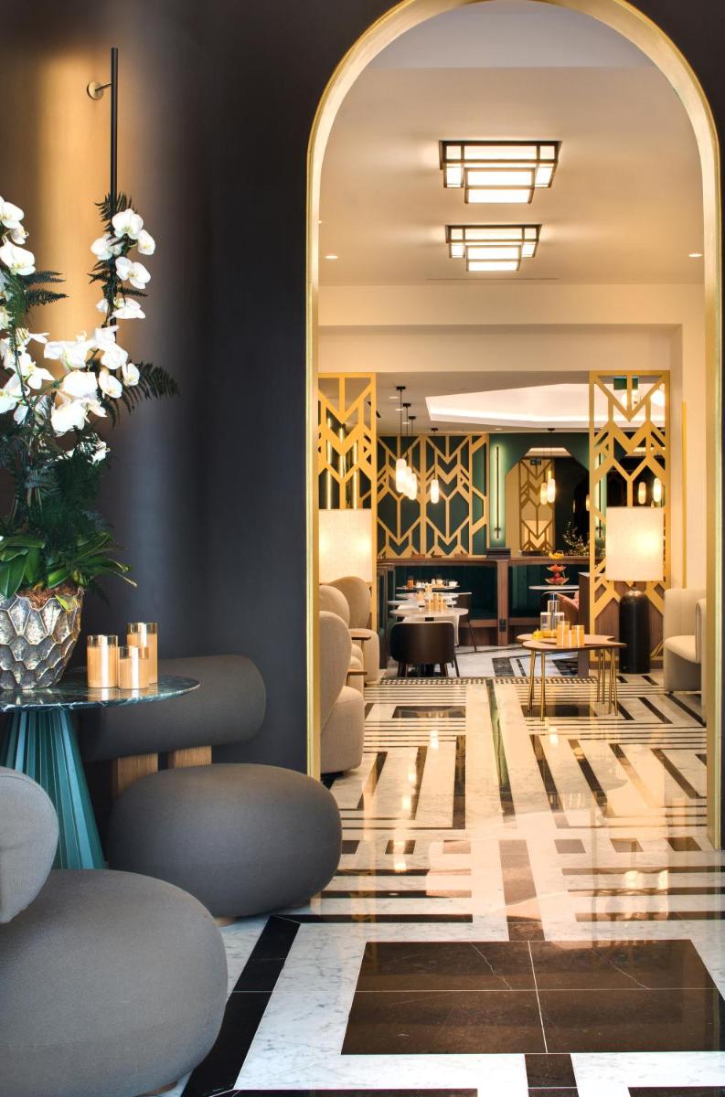 un hall d'entrée avec un miroir, des tables et des chaises dans l'établissement Hôtel Artemisia Montmartre, à Paris