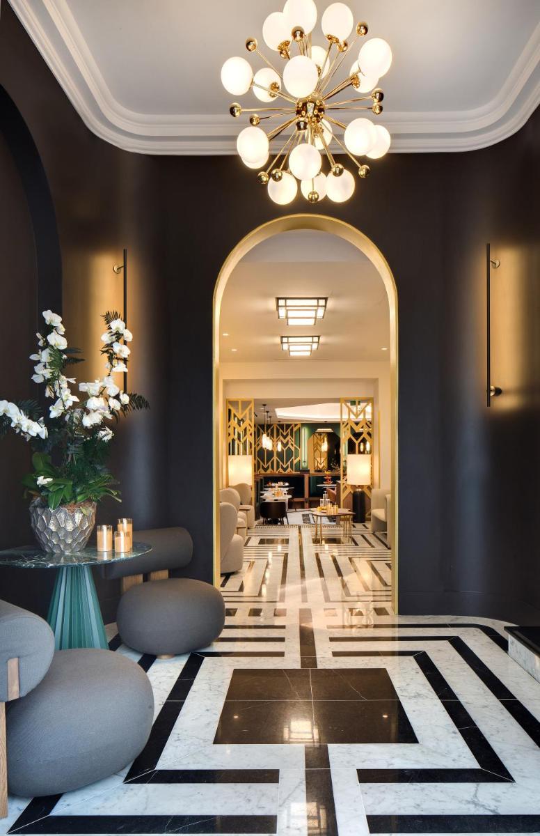 un hall d'entrée avec un lustre et un salon dans l'établissement Hôtel Artemisia Montmartre, à Paris