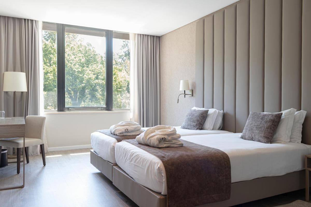 um quarto de hotel com duas camas e uma janela em MASA Hotel & Spa Campo Grande Collection em Lisboa