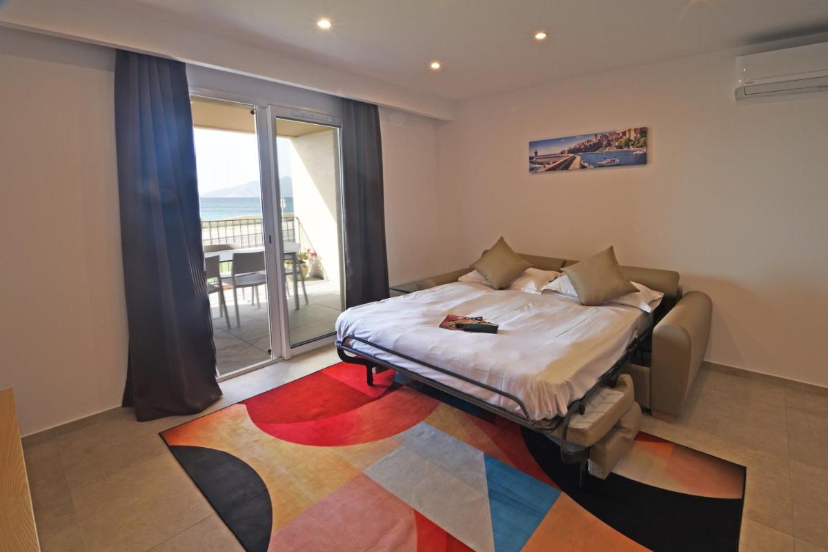 une chambre avec un lit et une grande fenêtre dans l'établissement Résidence Saint-Jean, à Saint-Florent