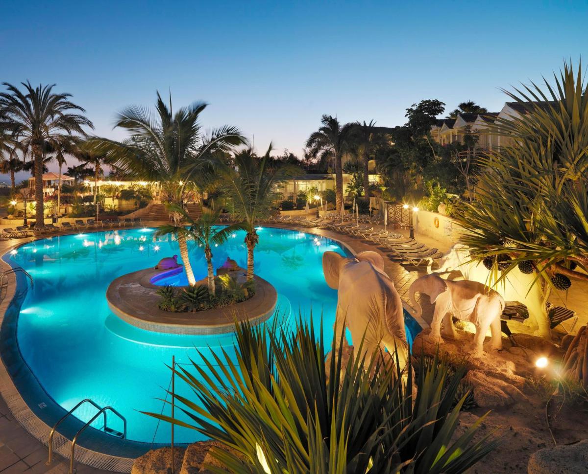 una piscina en un resort por la noche en Gran Oasis Resort, en Playa de las Américas