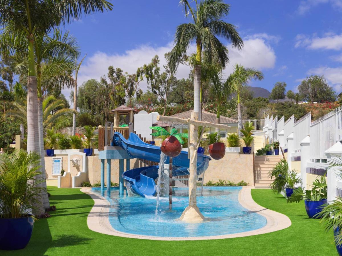 Un tobogán de agua en un complejo turístico con palmeras. en Gran Oasis Resort, en Playa de las Américas 34 fotos más