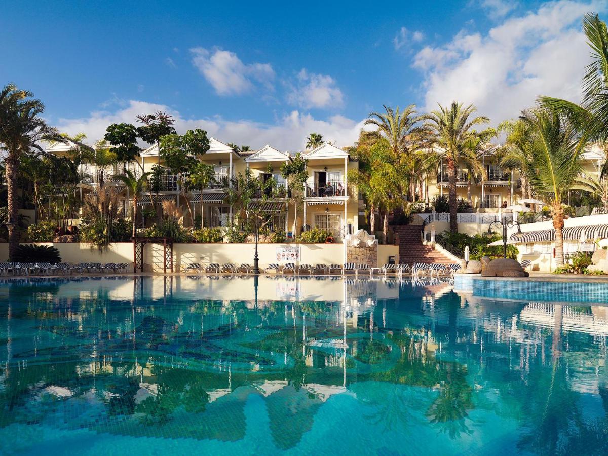 una piscina en un resort con palmeras en Gran Oasis Resort, en Playa de las Américas