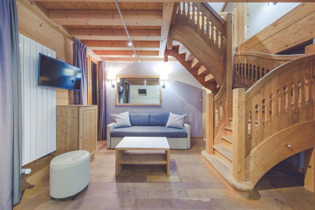 un salon avec un canapé et un escalier dans l'établissement Fleur De Neige Châtel, à Châtel