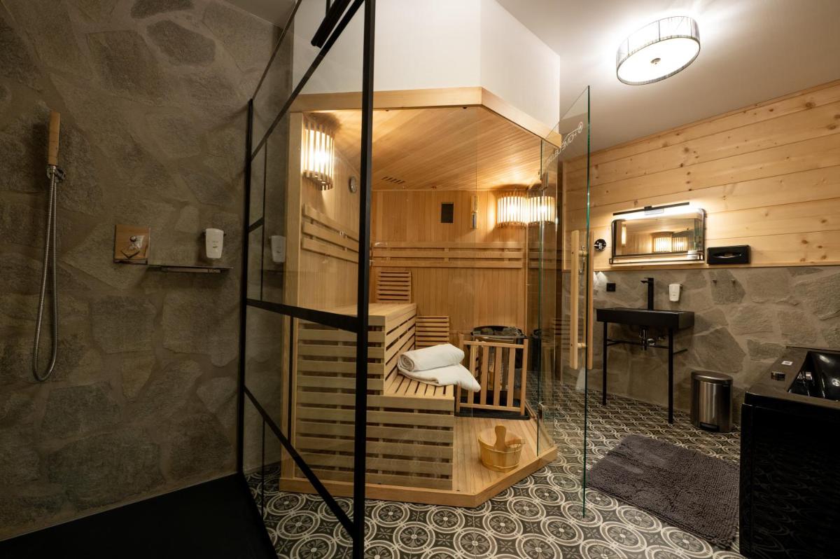 ein Bad mit einer ebenerdigen Dusche und einem Waschbecken in der Unterkunft ALPENLIEBE - Sauna & Whirlpool - APARTments in Inzell