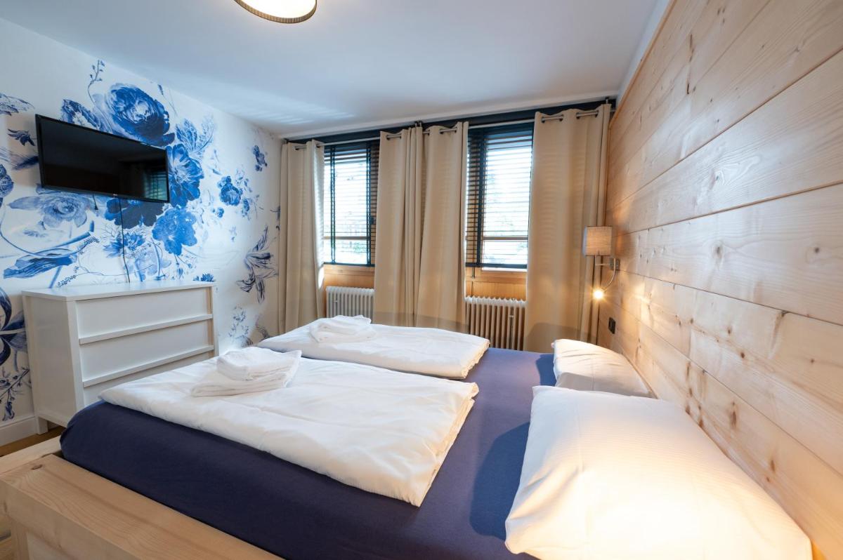 1 Schlafzimmer mit 2 Betten und einer Wand mit einem TV in der Unterkunft ALPENLIEBE - Sauna & Whirlpool - APARTments in Inzell