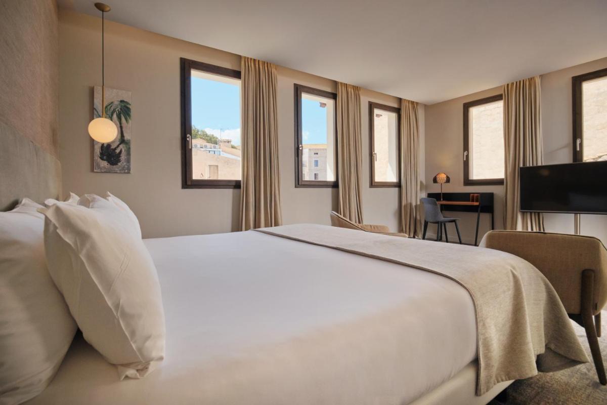 1 cama blanca grande en una habitación de hotel con ventanas en Sant Jaume Design Hotel, en Palma de Mallorca