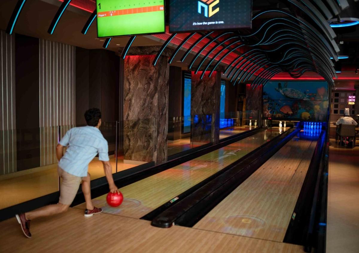a man throwing a ball at a bowling alley at JW Marriott Goa in Vagator a man throwing a ball at a bowling alley at JW Marriott Goa in Vagator