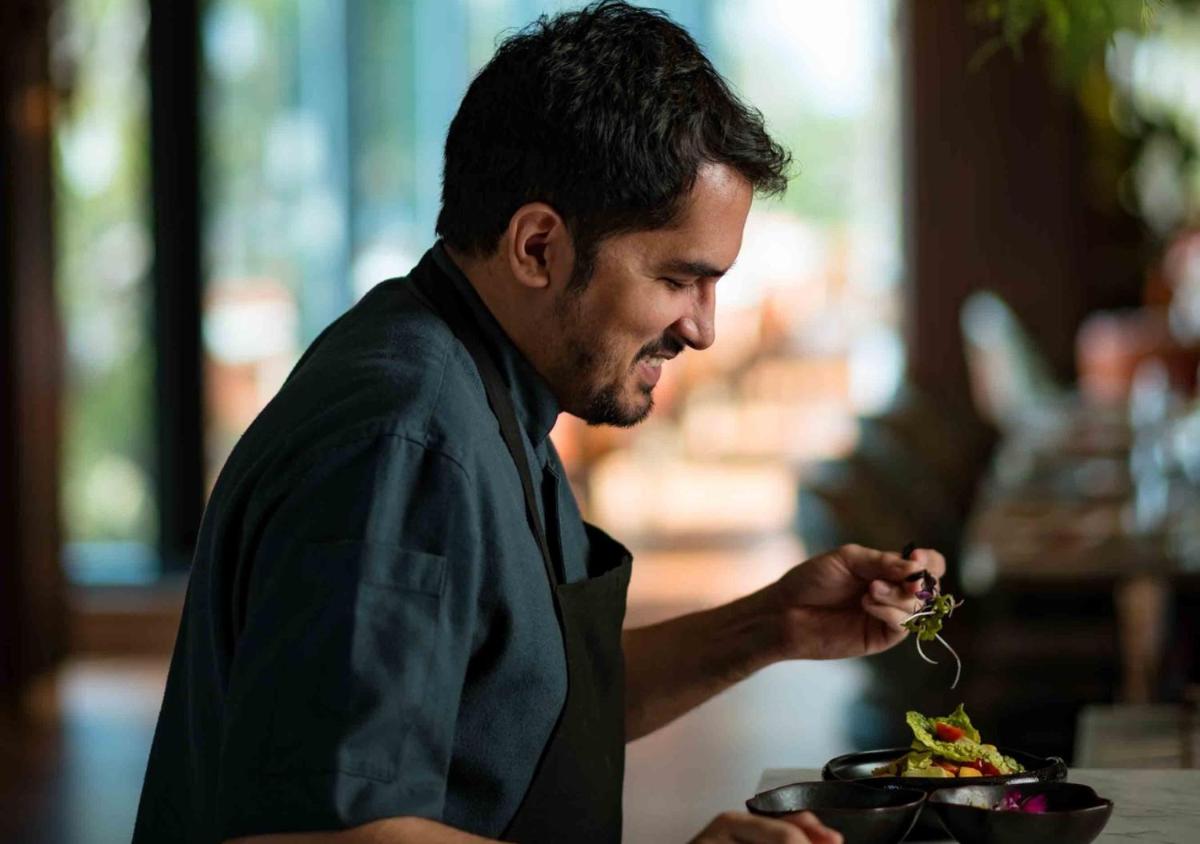 a man is eating a salad in a bowl at JW Marriott Goa in Vagator a man is eating a salad in a bowl at JW Marriott Goa in Vagator