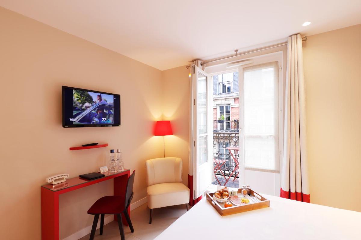 Cette chambre dispose d'un bureau, d'une chaise et d'une fenêtre. dans l'établissement Hotel Eden, à Paris