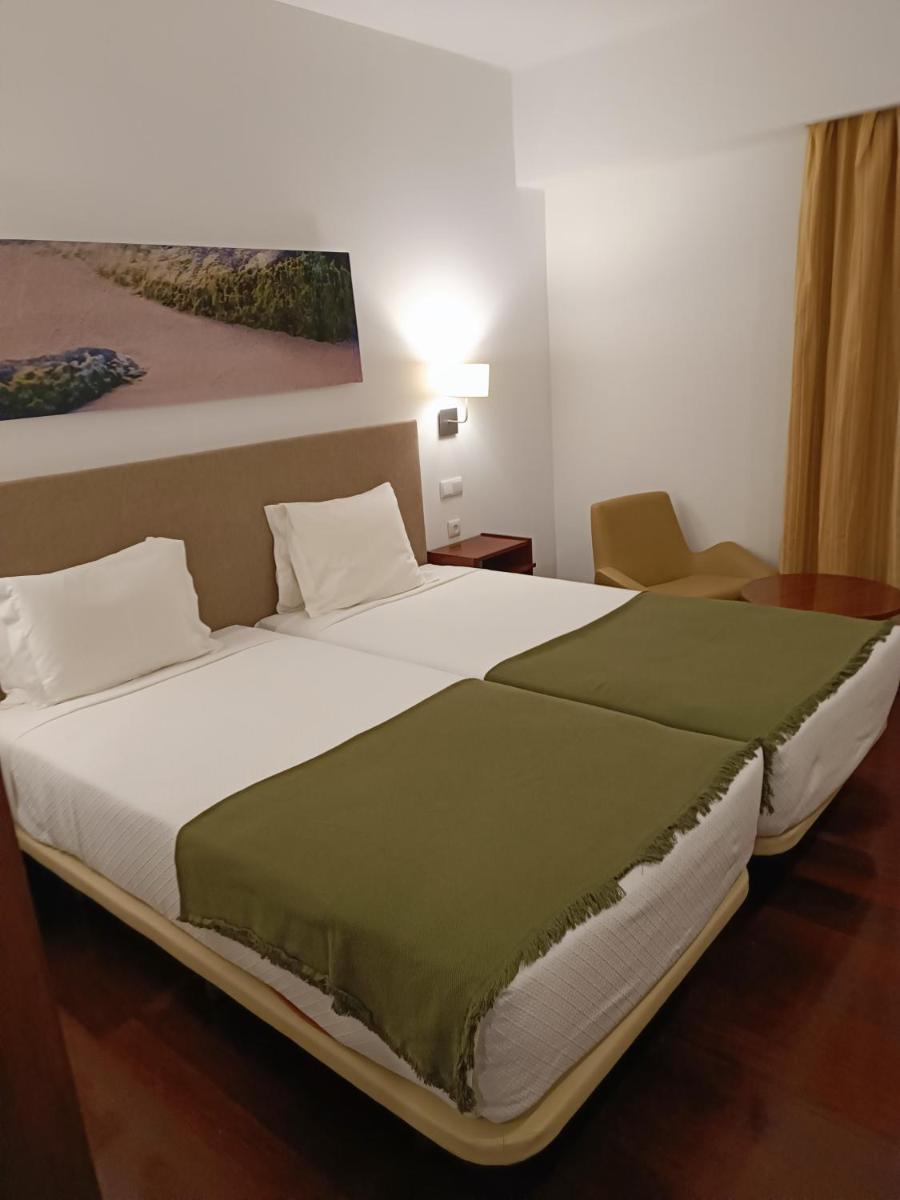 Uma cama ou camas num quarto em Hotel Porto Santo & Spa