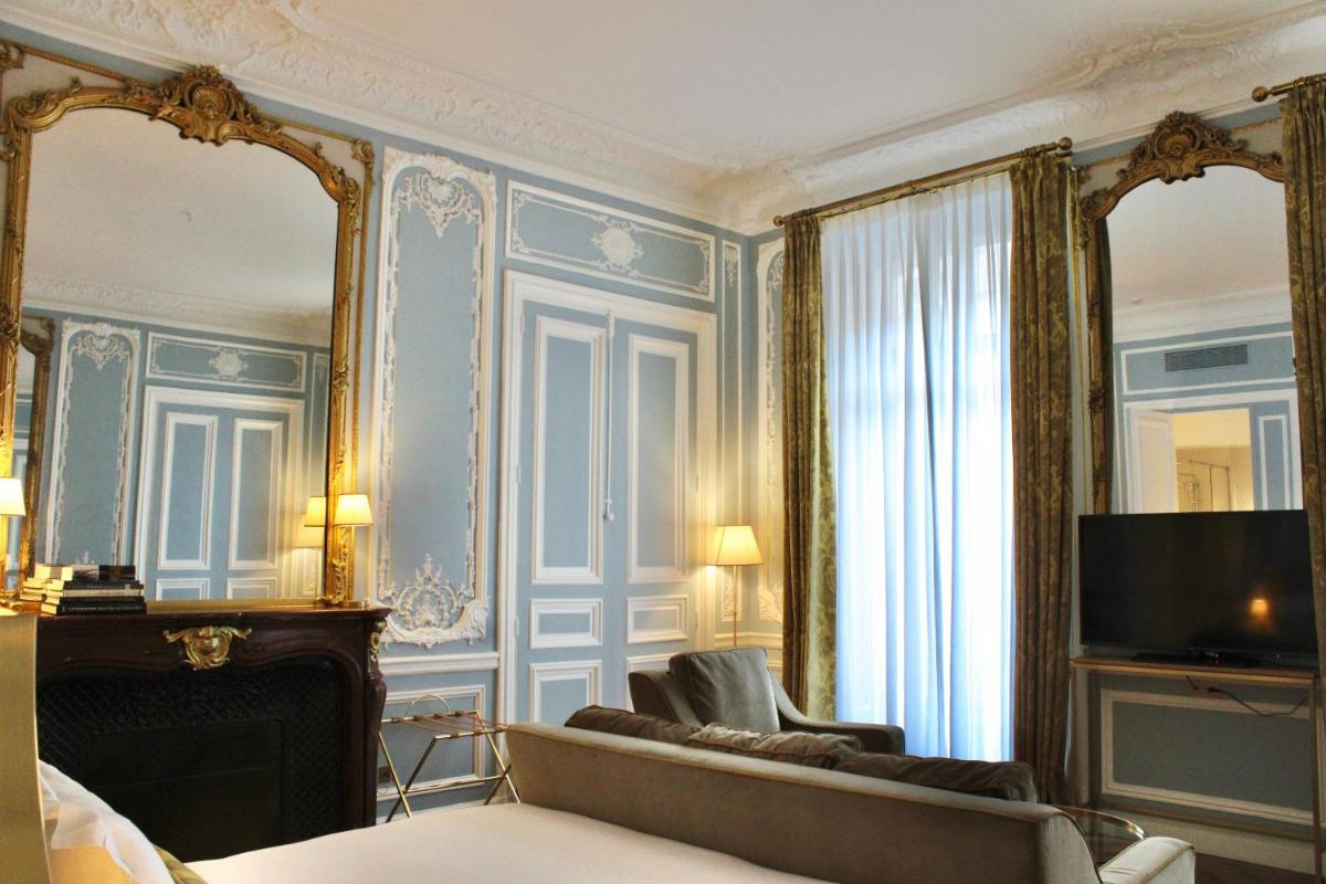 Cette chambre comprend un canapé, une télévision et un miroir. dans l'établissement Hôtel Alfred Sommier, à Paris
