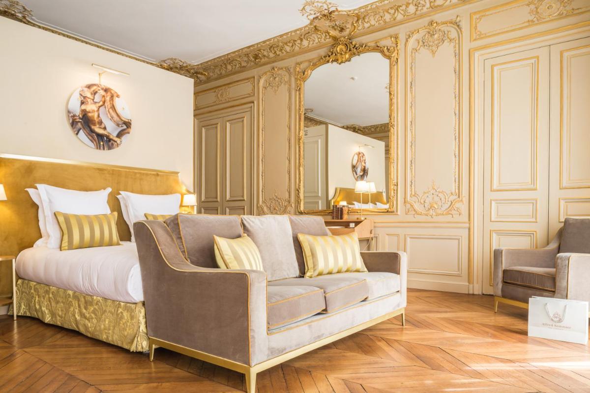 une chambre avec un lit, un canapé et un miroir dans l'établissement Hôtel Alfred Sommier, à Paris