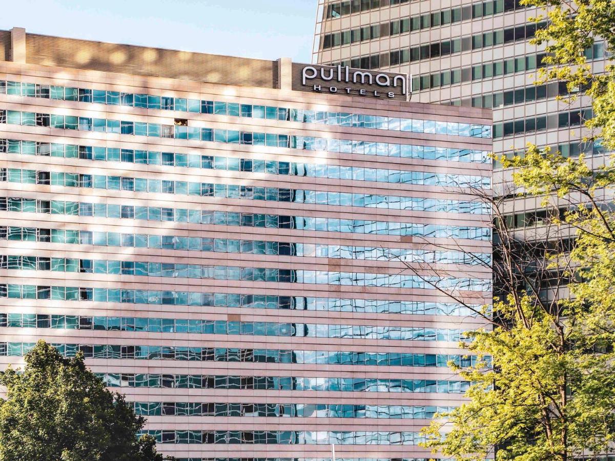 un grand bâtiment avec une enseigne au sommet dans l'établissement Pullman Paris La Défense, à Courbevoie