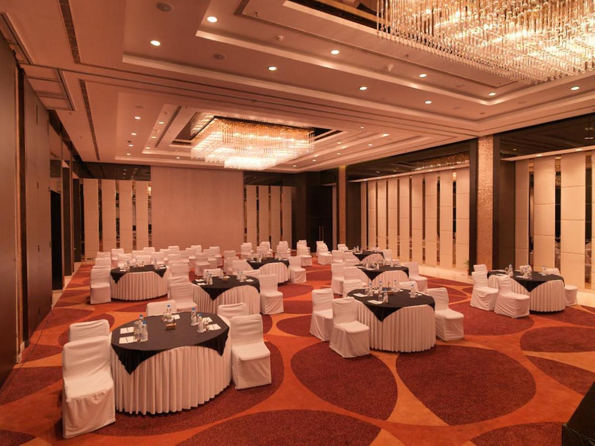 a banquet hall with white tables and white chairs at Hotel Royal Orchid Jaipur, Tonk Road in Jaipur