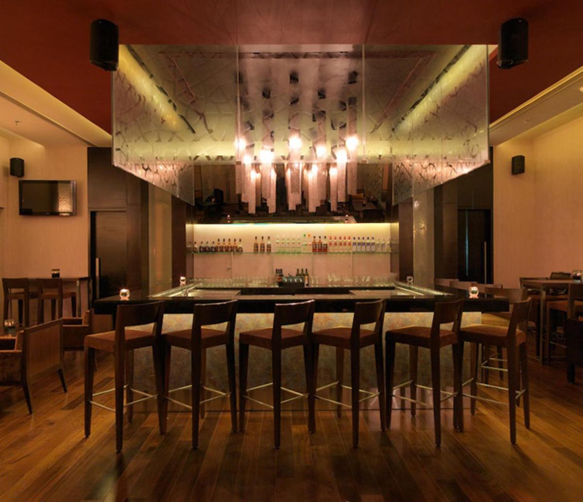 a restaurant with a bar with stools in a room at Hotel Royal Orchid Jaipur, Tonk Road in Jaipur