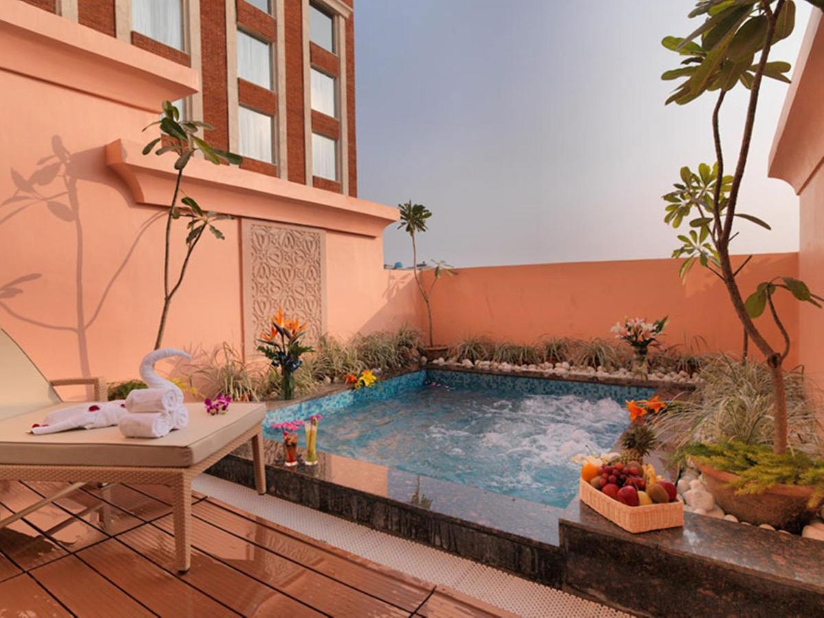 a swimming pool in the middle of a building at Hotel Royal Orchid Jaipur, Tonk Road in Jaipur