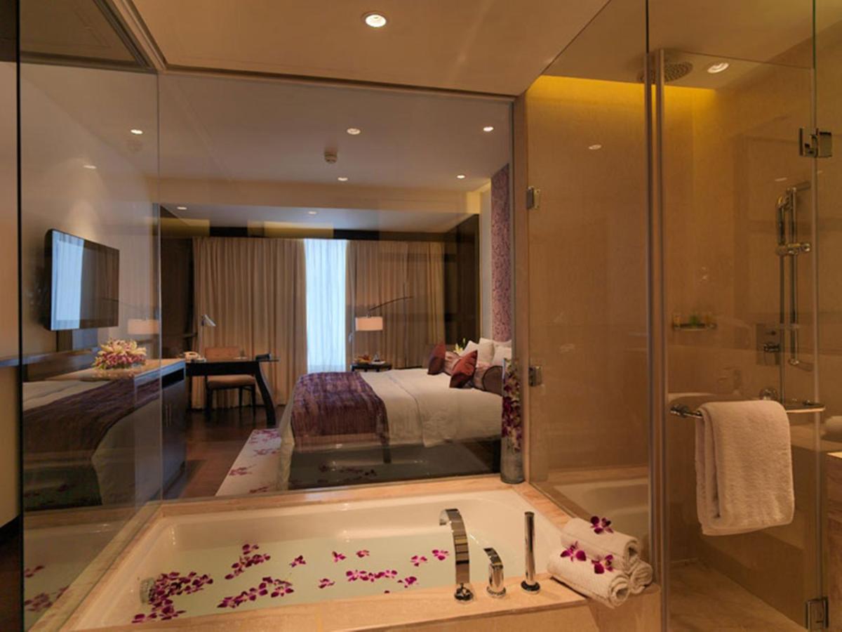 a bathroom with a bath tub and a bedroom at Hotel Royal Orchid Jaipur, Tonk Road in Jaipur