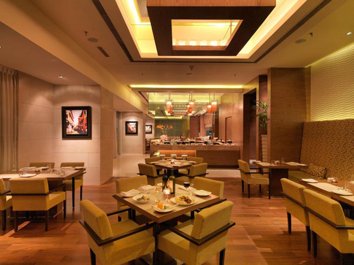 a dining room with tables and chairs and a restaurant at Hotel Royal Orchid Jaipur, Tonk Road in Jaipur