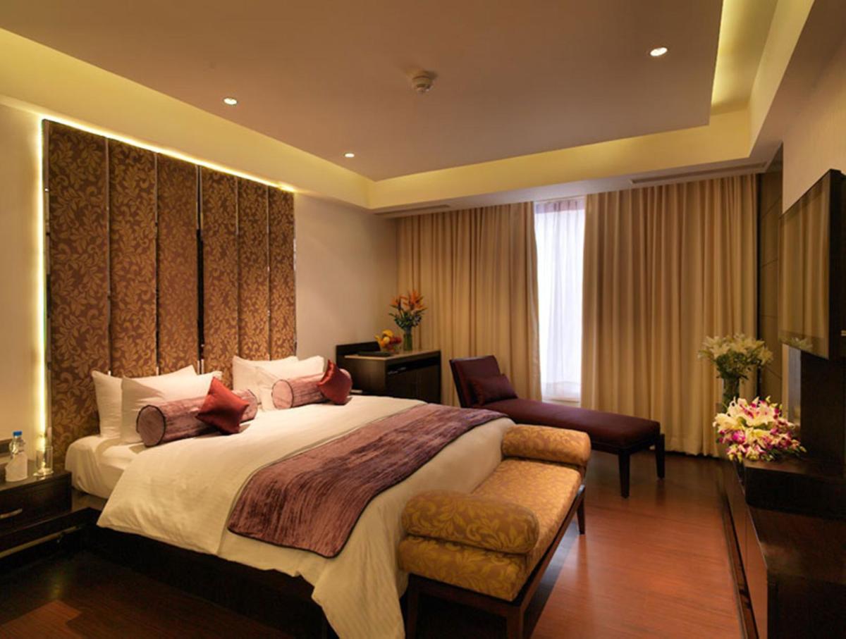 a large bedroom with a large bed and a couch at Hotel Royal Orchid Jaipur, Tonk Road in Jaipur