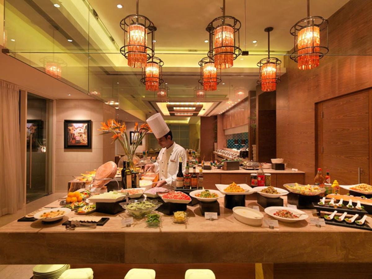 a chef in a kitchen preparing food in a restaurant at Hotel Royal Orchid Jaipur, Tonk Road in Jaipur