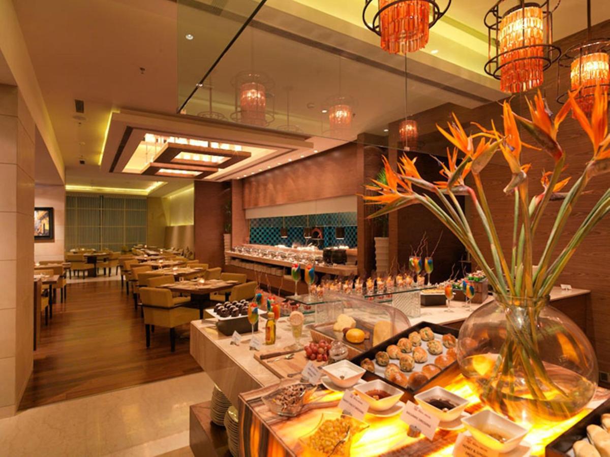 a restaurant with tables and a vase of flowers at Hotel Royal Orchid Jaipur, Tonk Road in Jaipur