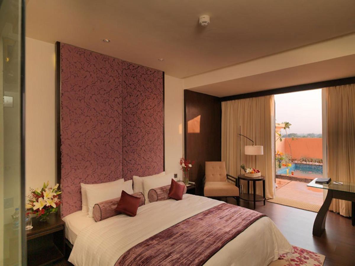 a bedroom with a large bed with a large window at Hotel Royal Orchid Jaipur, Tonk Road in Jaipur
