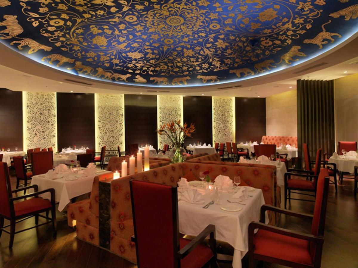 a dining room with tables and chairs and a ceiling at Hotel Royal Orchid Jaipur, Tonk Road in Jaipur