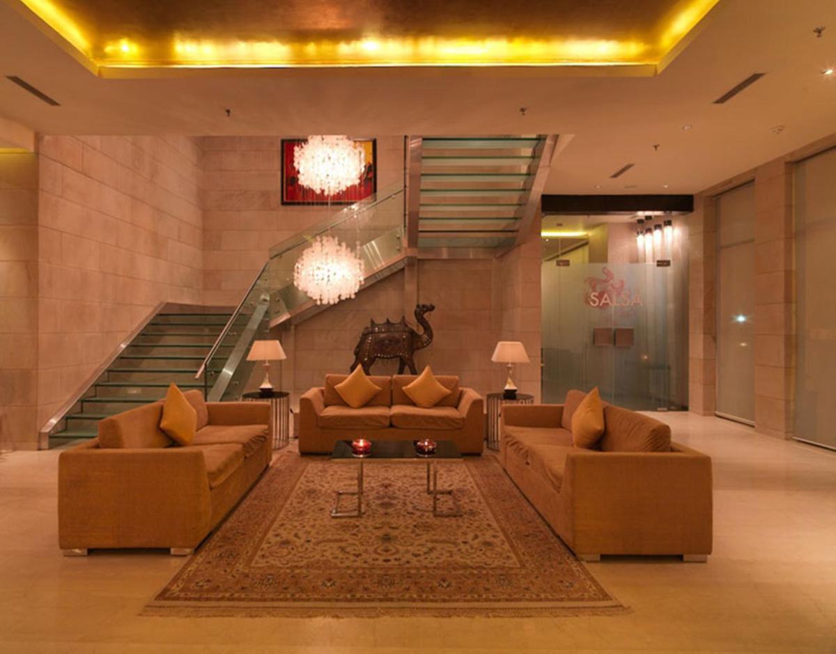 a living room with two couches and a staircase at Hotel Royal Orchid Jaipur, Tonk Road in Jaipur