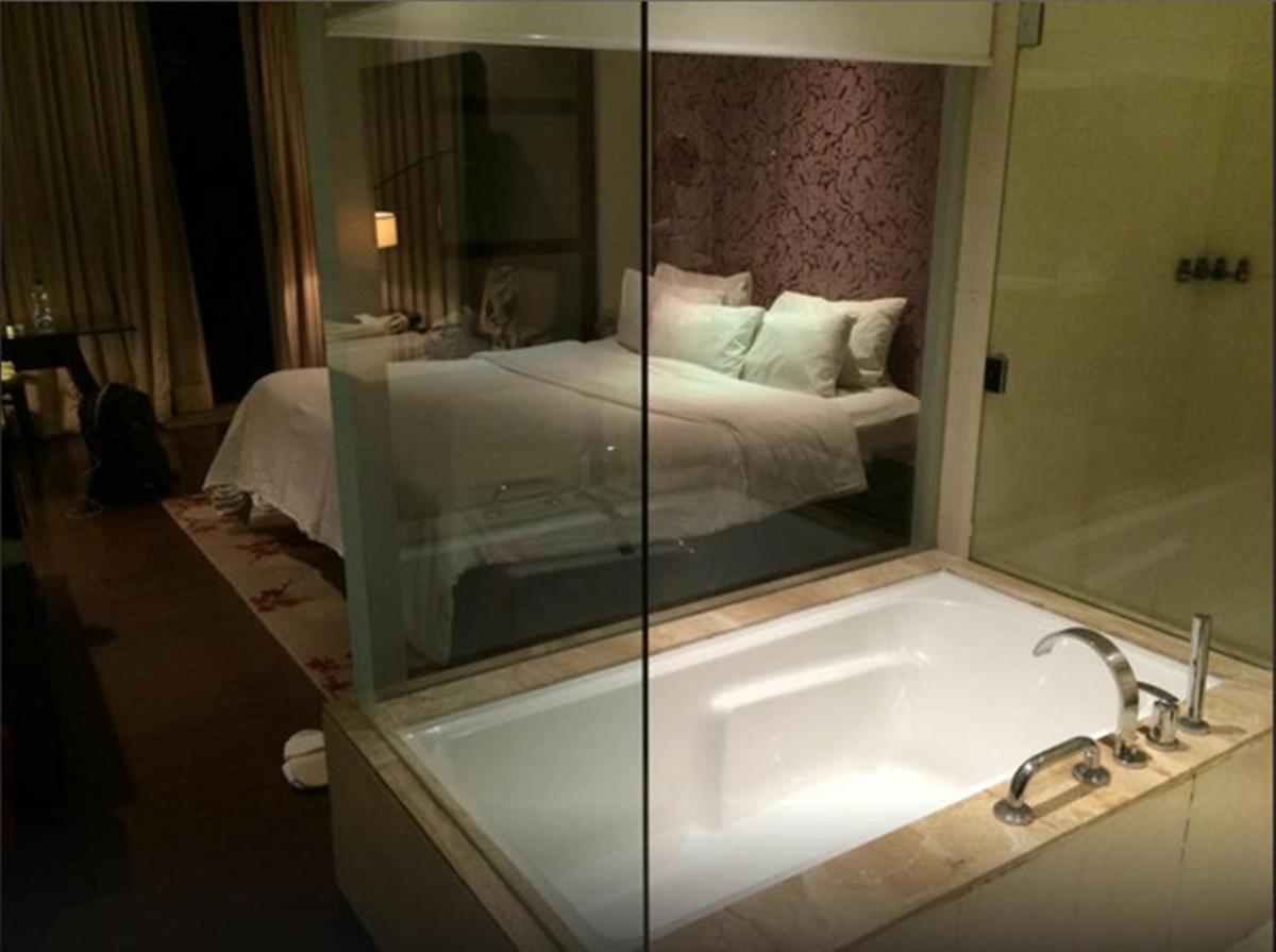 a bathroom with a tub and a bedroom with a bed at Hotel Royal Orchid Jaipur, Tonk Road in Jaipur
