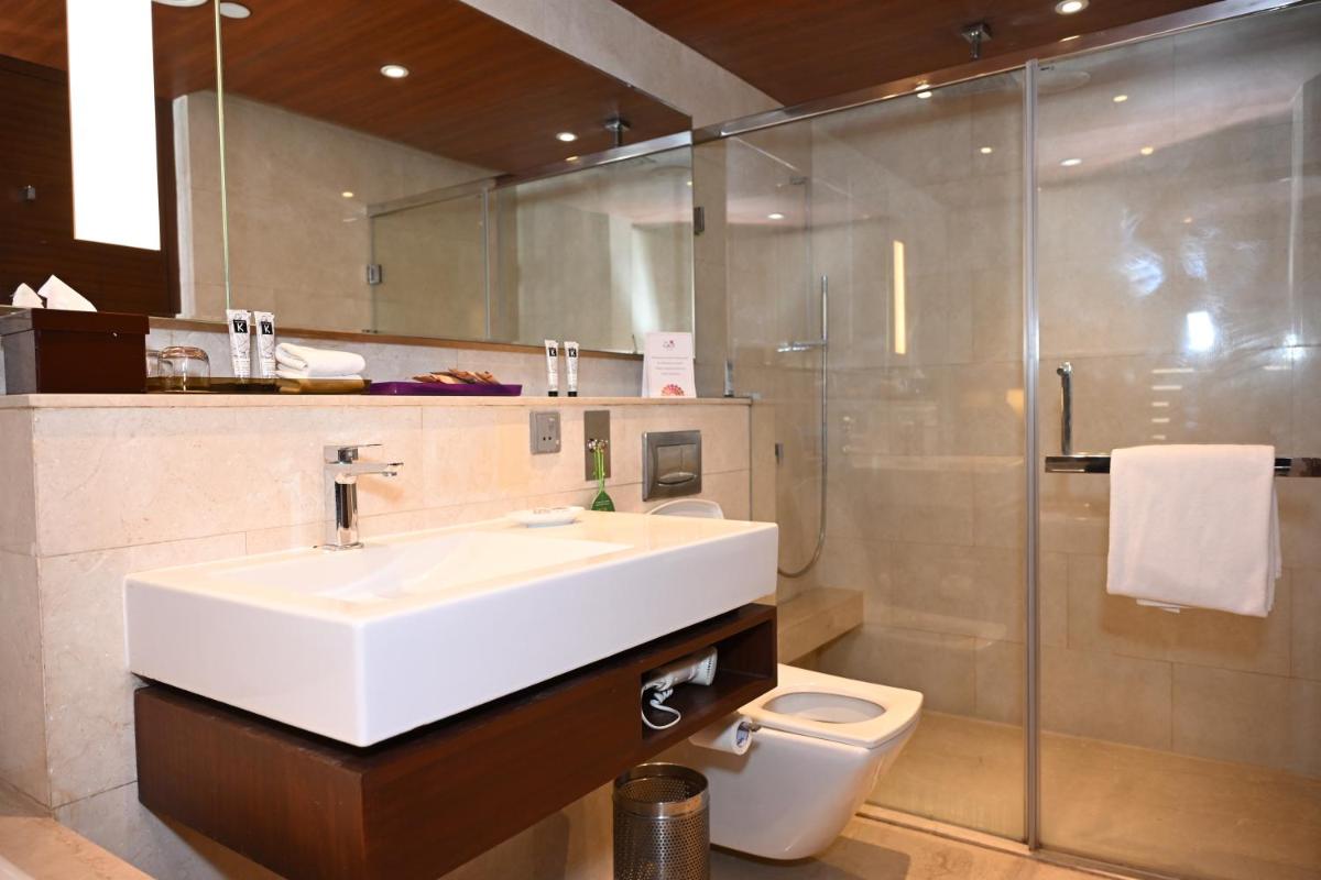 a bathroom with a sink and a toilet at The LaLiT New Delhi in New Delhi