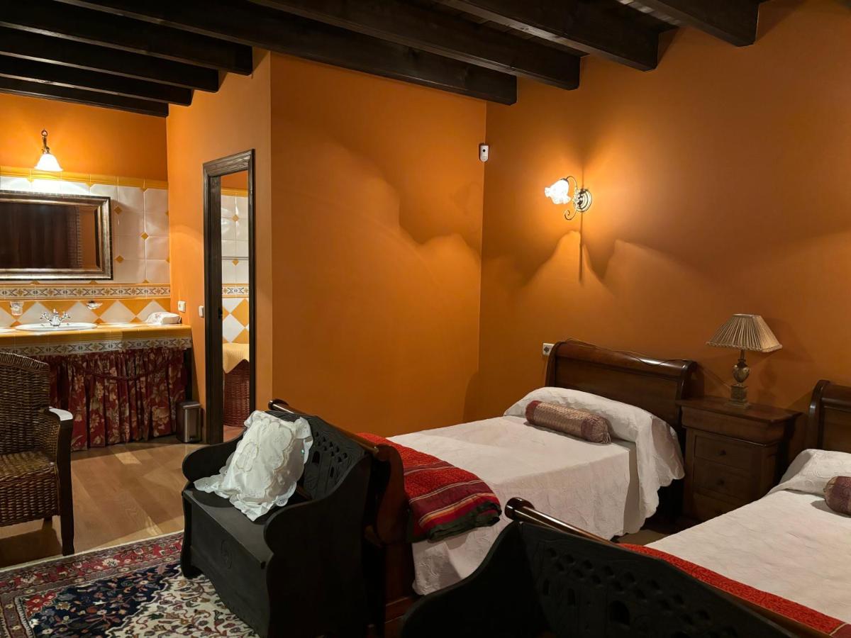 Un dormitorio con dos camas y una silla y un espejo. en Terraplén Seis Boutique Hotel, en Fermoselle