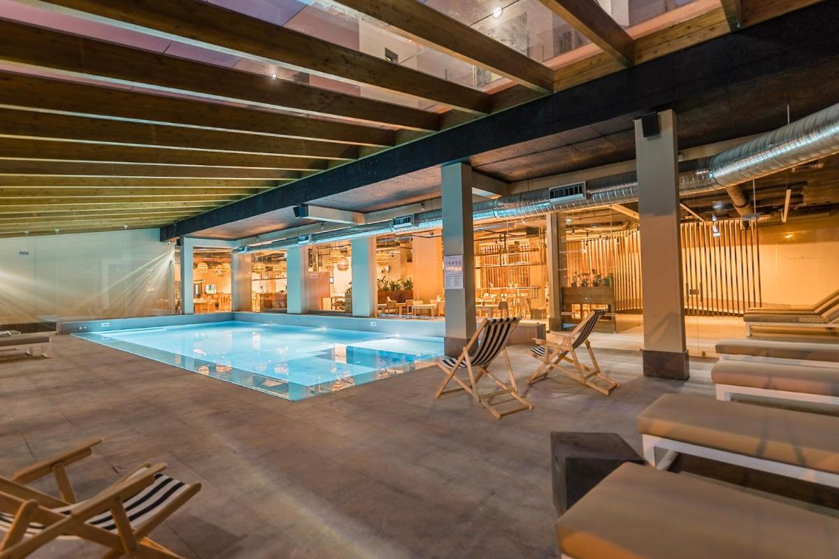 uma piscina num edifício com cadeiras à volta em You and the sea na Ericeira mais 58 fotografias