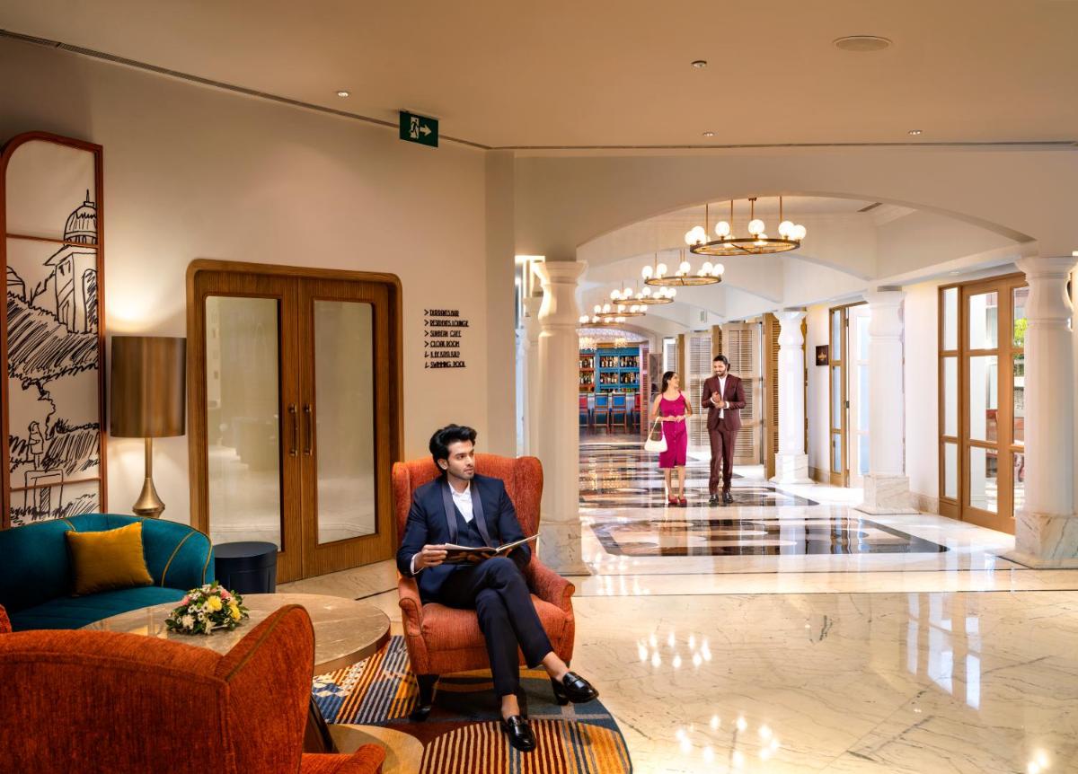 a man sitting in a chair in a lobby at Welcomhotel by ITC Hotels, Cathedral Road, Chennai in Chennai