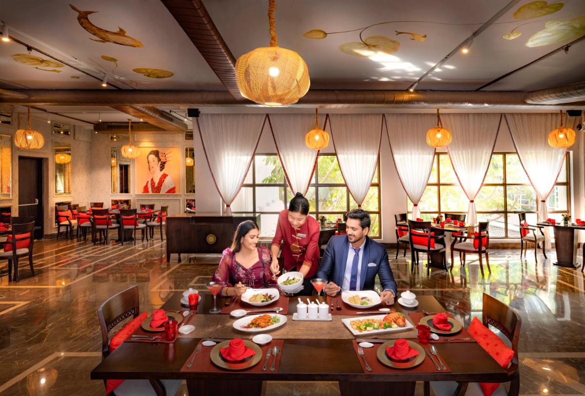 a group of people sitting at a table in a restaurant at Welcomhotel by ITC Hotels, Cathedral Road, Chennai in Chennai