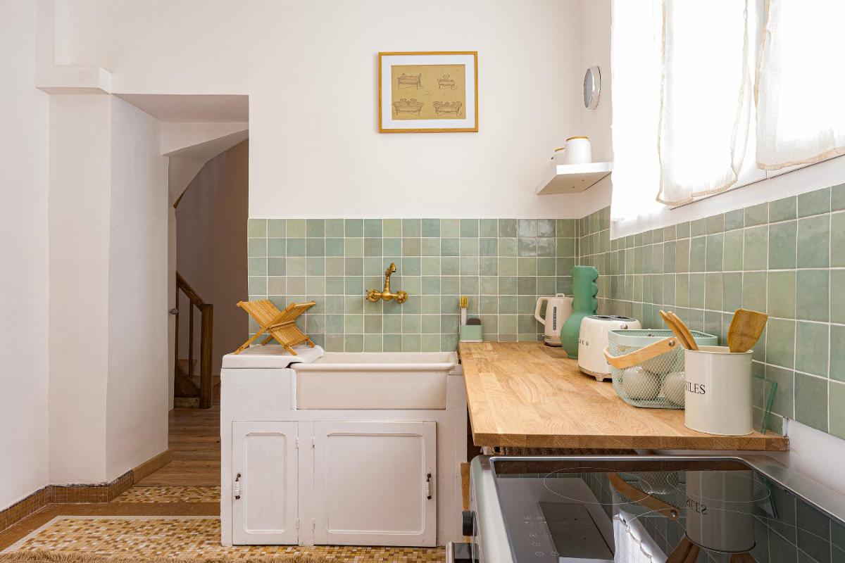 une cuisine avec des placards blancs et du carrelage vert dans l'établissement Château de Tressé, à Pouancé une cuisine avec des placards blancs et du carrelage vert dans l'établissement Château de Tressé, à Pouancé