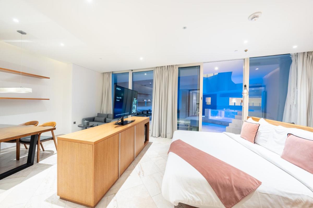 a bedroom with a king sized bed and a desk at FIVE Jumeirah Village in Dubai