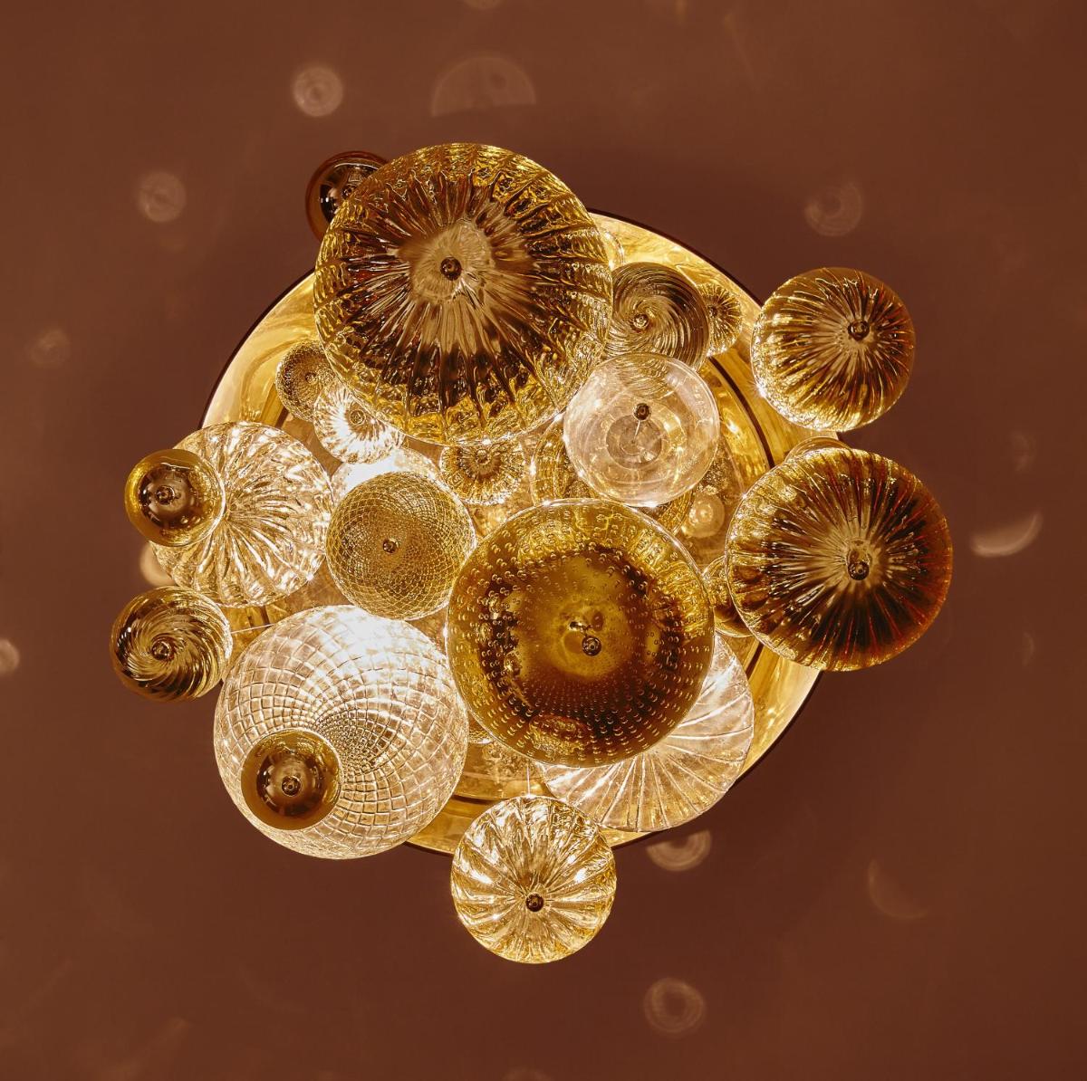 a circular gold chandelier with many clear glass bulbs at Taj Santacruz in Mumbai