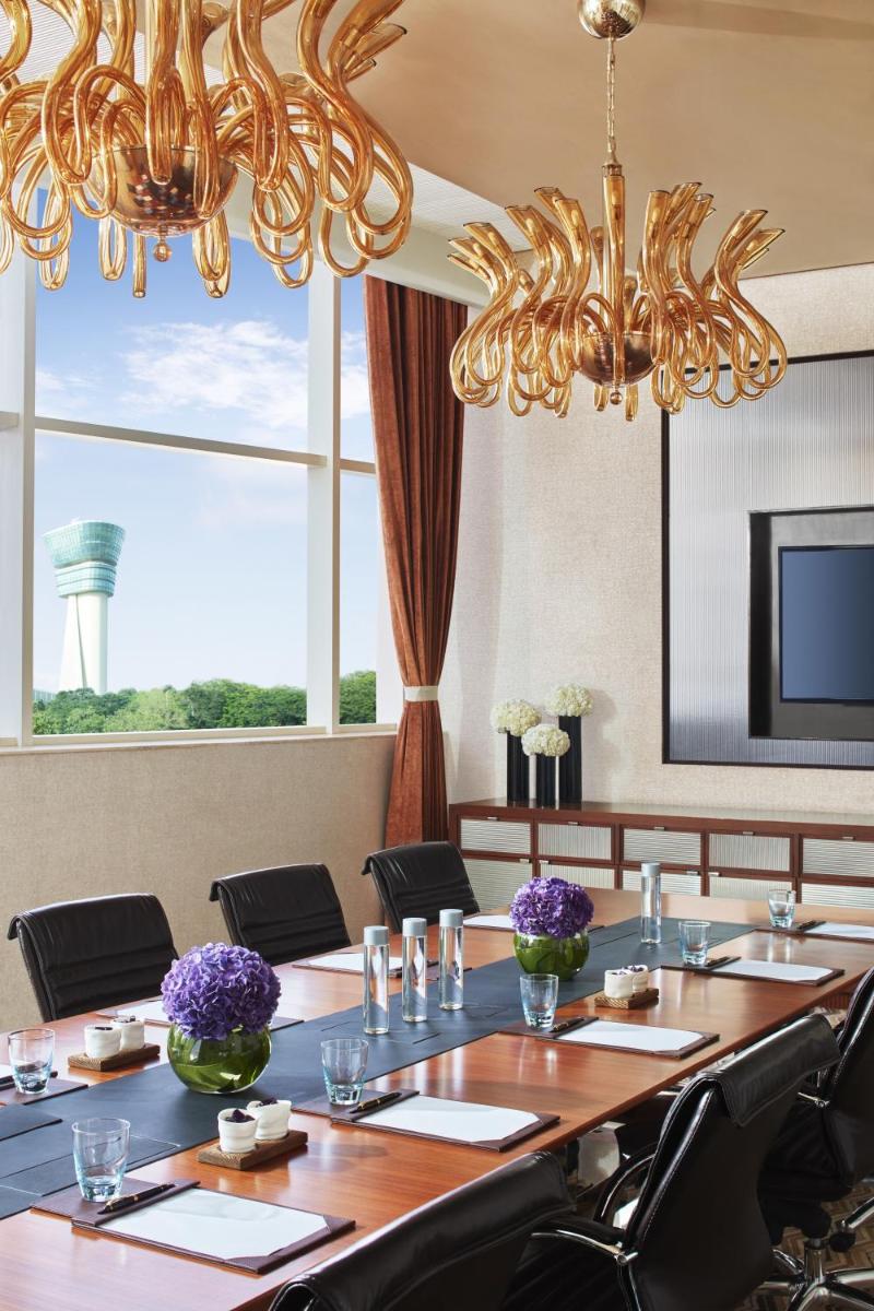 a conference room with a long table and a chandelier at Taj Santacruz in Mumbai