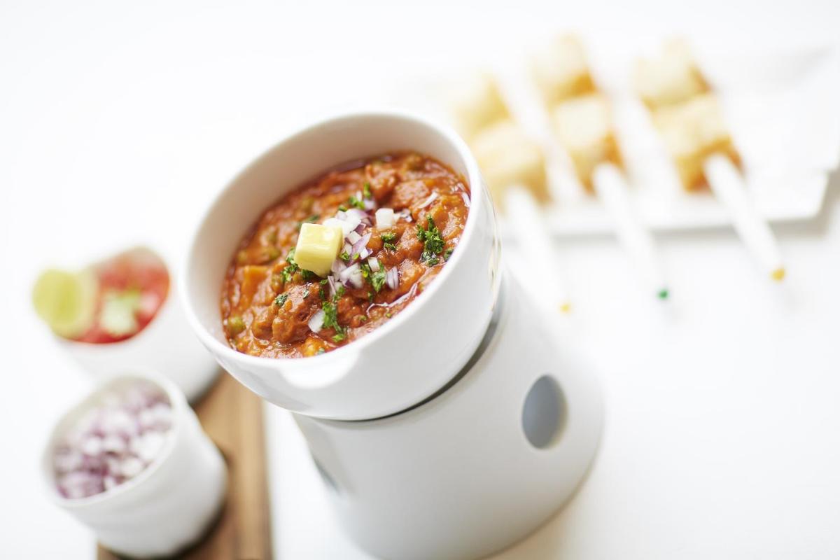 a bowl of chili sitting on top of a table at Taj Santacruz in Mumbai