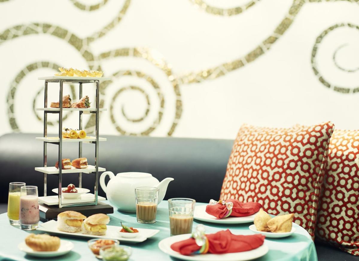 a table with plates of food on top at Taj Santacruz in Mumbai