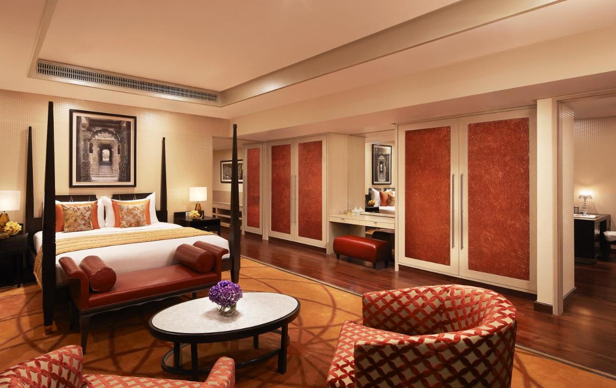 a hotel room with a bed and a table and chairs at Taj Santacruz in Mumbai