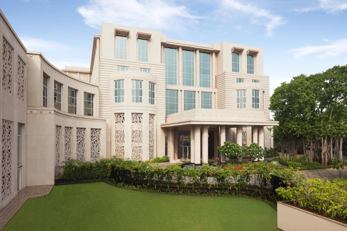 a large building with a green lawn in front of it at Taj Santacruz in Mumbai